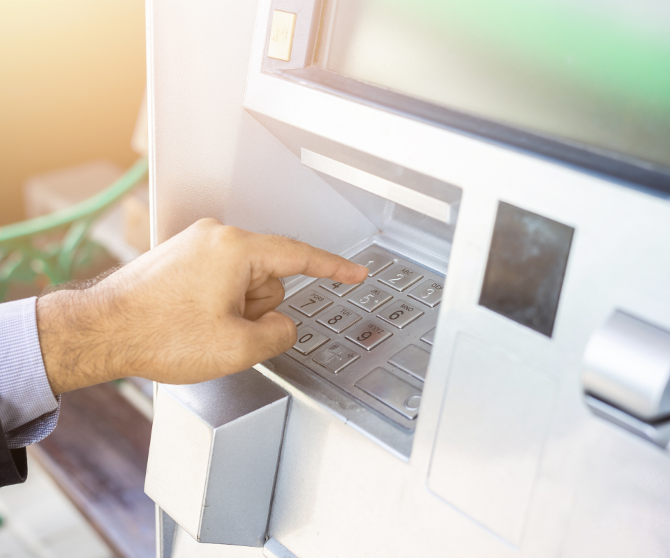 Close up of a male hand using an atm machine 